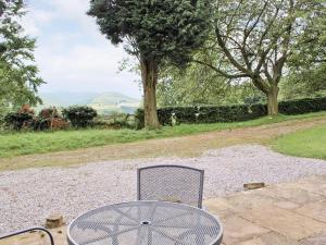 a metal table and chair sitting on a gravel patio at Winhill Cottage in Bamford