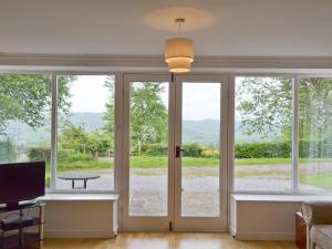a living room with sliding glass doors with a view at Winhill Cottage in Bamford