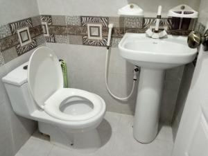 a bathroom with a white toilet and a sink at Hill view Guest House near continental bakery Johar Darul sehat, Agha khan and Liaqat Hospital in Karachi