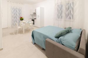 Habitación blanca con cama y sofá en Pietra Fiorita Dimora, en Conversano