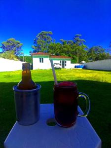 two cups of tea and a bottle on a table at CASA PRAIA PINHEIRA e GUARDA EMBAU in Palhoça