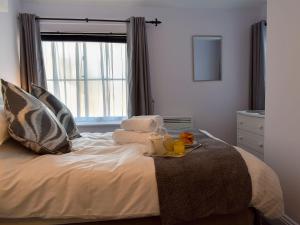 a bed with a tray of towels and a window at Garden View Apartment in Sneaton