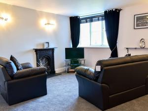 uma sala de estar com dois sofás e uma televisão em Garden View Apartment em Sneaton