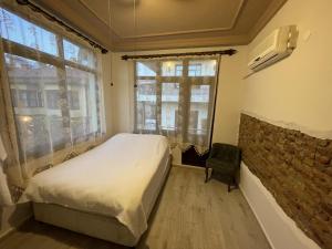 a bedroom with a bed and a brick wall at Hıdırlık Boutique Hotel in Antalya