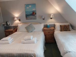 ein Schlafzimmer mit 2 Betten und Handtüchern darauf in der Unterkunft The Norwood in Torquay