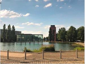 um edifício de vidro sentado em cima de uma massa de água em Myroom Business Apartment Nähe Messe München em Munique