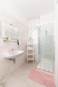 y baño blanco con lavabo y ducha. en Pietra Fiorita Dimora, en Conversano
