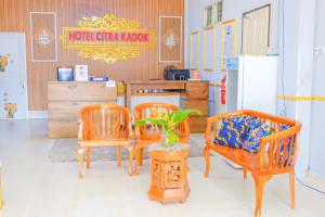 a room with three chairs and a table and a refrigerator at Citra Kadok Hotel & Banquet Hall in Kota Bharu