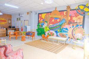 um quarto com cadeiras e uma grande pintura na parede em Citra Kadok Hotel & Banquet Hall em Kota Bharu
