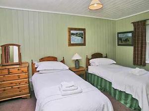 Kirkpatrick DurhamにあるMarwhin Cottage - Swwsのベッドルーム1室(ベッド2台、ドレッサー、鏡付)