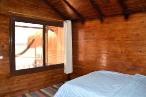 a bedroom with a bed and a window with a view at Shanty beach camp suer in Nuweiba