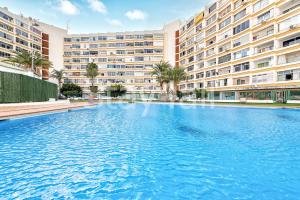 a large swimming pool in front of a large building at Apartamento Los Molinos in Playa del Ingles
