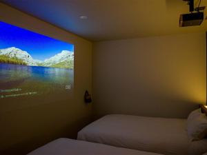 富士河口湖的住宿－Rakuten STAY Fuji Kawaguchiko Station - Japanese Modern Villa Mt Fuji View 106，一间卧室设有两张床,墙上配有电视。
