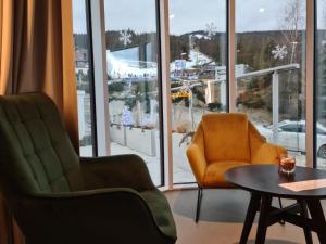 a living room with two chairs and a table at Apartament Biała Perła in Sienna