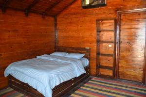 a small bed in a room with wooden walls at Shanty beach camp suer in Nuweiba