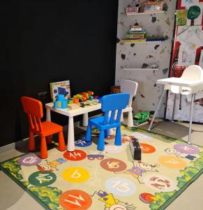 a toy table and chairs on a rug with a table and chairs at Apartament Biała Perła in Sienna