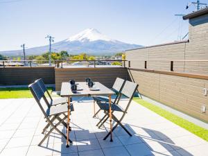 uma mesa e cadeiras num pátio com uma montanha ao fundo em Rakuten STAY Fuji Kawaguchiko Station - Japanese Modern Villa Mt Fuji View 107 em Fujikawaguchiko