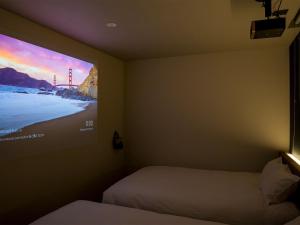 a room with two beds and a tv on the wall at Rakuten STAY Fuji Kawaguchiko Station - Japanese Modern Villa Mt Fuji View 107 in Fujikawaguchiko