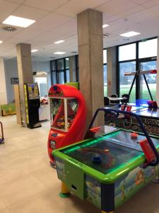 a room with a pinball machine and a table at Apartament Biała Perła in Sienna