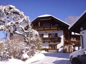 un gran edificio con árboles nevados delante de él en Ferienwohnungen Vogelrast, en Berchtesgaden