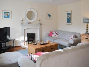 a living room with a couch and a table at 61 Longstone Close in Beadnell