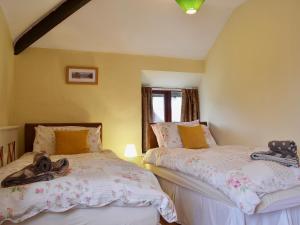 two twin beds in a room with yellow walls at Helm View in Windermere