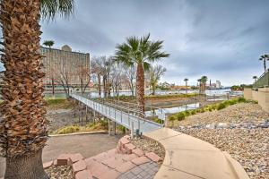 a walkway in a park with palm trees and a building at Step-Free Bullhead City Condo with Balcony! in Bullhead City