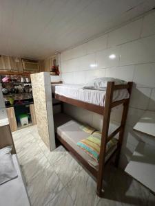 Våningssäng eller våningssängar i ett rum på Kitnets com AR Condicionado na Praia