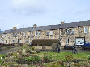 a large brick building with a garden in front of it at The Lobster Pot in Amble