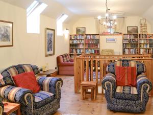een woonkamer met 2 stoelen en boekenplanken bij The Granary in Lanton