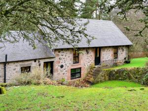 een oud stenen huis met een trap in een tuin bij The Granary in Lanton