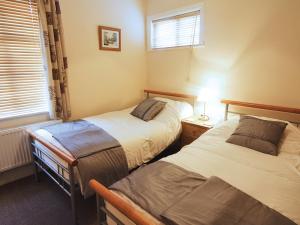 a bedroom with two beds and a window at Berwyn Stationmasters House - Hw7641 in Llangollen