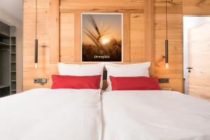 Duas camas com almofadas vermelhas num quarto em Chalet-Ferienwohnung Ährenglück, 70 qm, Wellness/Fitness/Sauna – Bergrödelhof em Feilitzsch