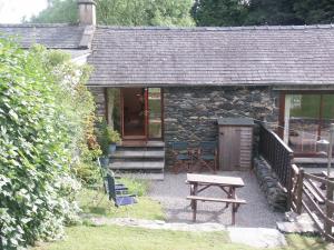 Ce cottage en pierre dispose d'une table de pique-nique et d'un banc. dans l'établissement Applecroft, à Keswick