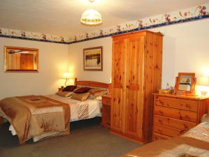 - une chambre avec un lit, une commode, un lit et une armoire dans l'établissement Applecroft, à Keswick