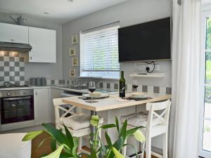 a kitchen with a table with two glasses of wine at Petit Knowle in Cuckfield