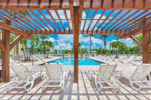 una piscina con sedie bianche e pergolato in legno di Islamorada Paradise Overlooking the Fabulous Florida Bay. a Tavernier