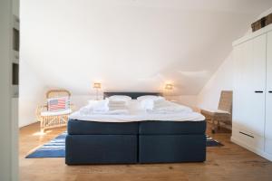 a bedroom with a large blue bed in a room at Ferienhaus DHH SKILLEHUS in Tating