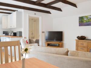ein Wohnzimmer mit einem Sofa und einem Tisch in der Unterkunft Bluebell Cottage in Nether Stowey