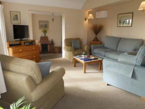 a living room with two couches and a tv at Monks Thatch in Otterton