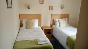 two beds in a hotel room withskirts at Star Hotel in Kirkcudbright