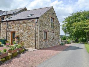an old stone house with a driveway at Ellen Cottage in Ireby