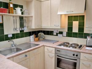 een keuken met een wastafel en een fornuis top oven bij Hydrangeas in Malborough