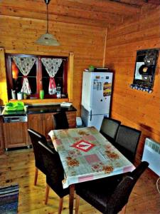 eine Küche mit einem Tisch mit Stühlen und einem Kühlschrank in der Unterkunft Rozprávkový zrub in Dúbrava