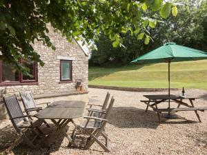 a picnic table and chairs with a table and an umbrella at Bramble Cottage in Radstock