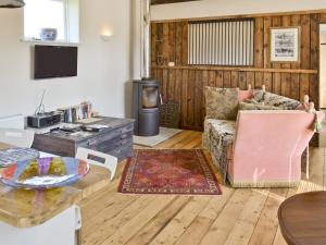 - un salon avec un canapé et une table dans l'établissement Evie Rose Cottage, à Elsenham