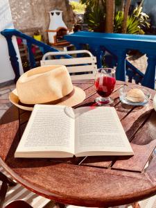 un libro sobre una mesa con un sombrero y una copa de vino en A Alma Portuguesa en Fátima