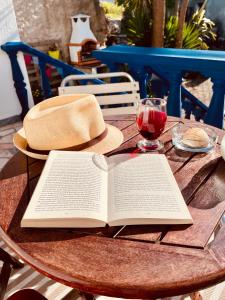 a book on a table with a hat and a glass of wine at A Alma Portuguesa in Fátima