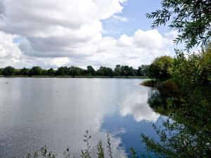 a large body of water with trees and clouds at Apartment 2 in South Cerney