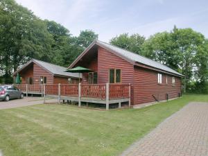 a log cabin with a porch and a car parked in front at Fairways Lodge in Bridlington